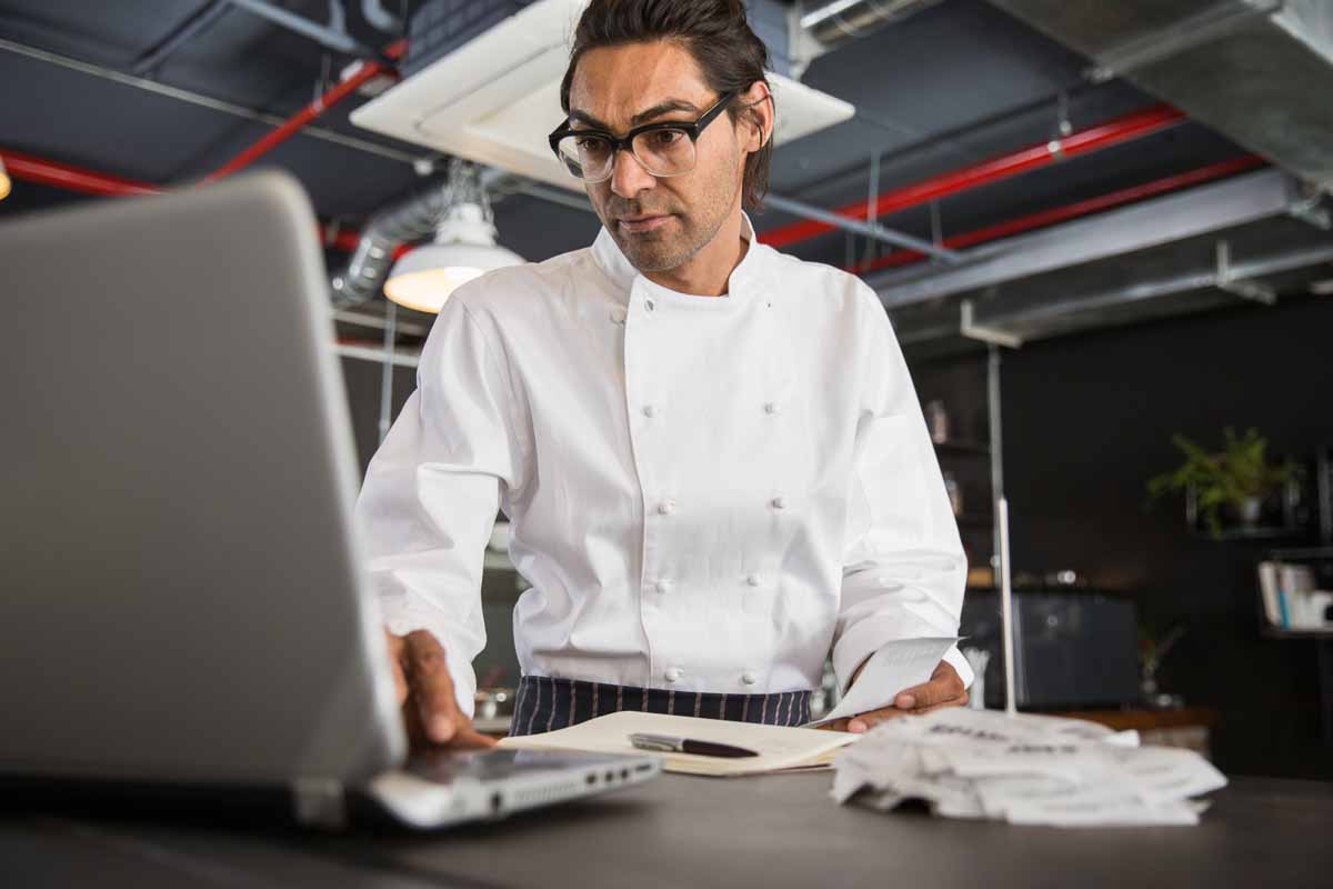 chef de cozinha trabalhando em um laptop