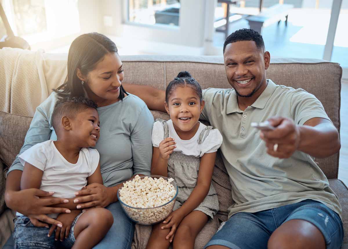 Pais, filhos e família feliz assistindo tv, filme e mídia, programa de tv e filme de desenho animado em casa.