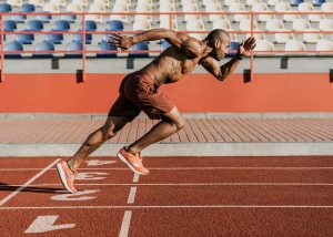 Atleta correndo em uma pista de corrida, exemplo de performance, nicho do mercado de trabalho para educação física