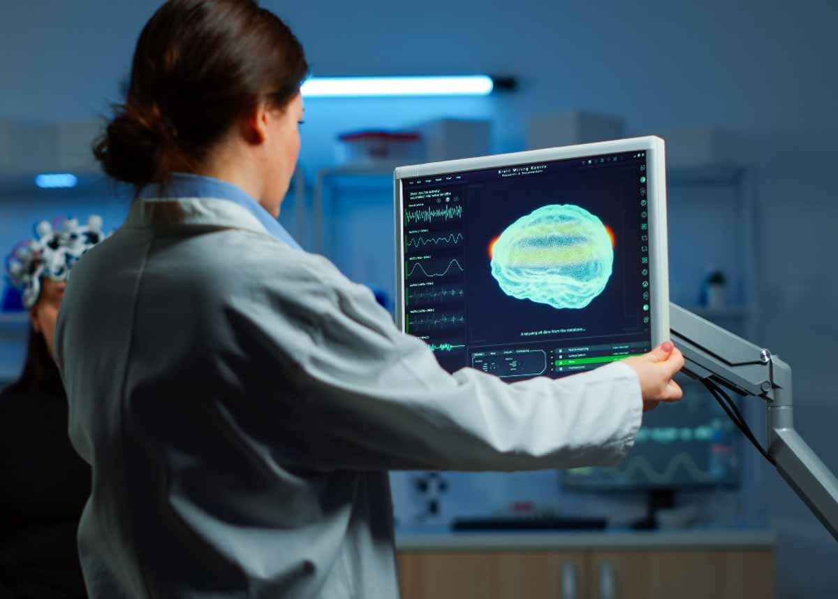 médica olha para imagem de mapeamento cerebral em um monitor